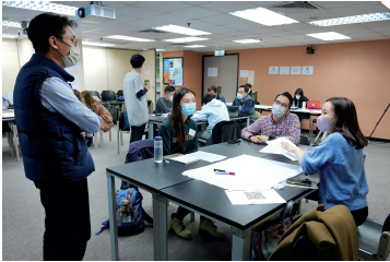 Self Photos / Files - A coach (L) guiding the discussion of a group of participants